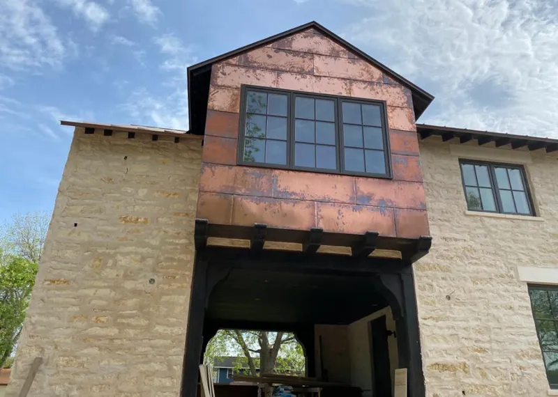 Copper metal panel facade on a stone building for Skylight Installation in Statesville