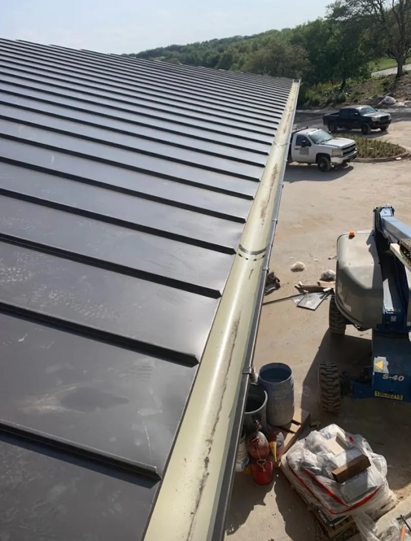 Standing seam panel and gutter detail on a metal roofing jobsite in Statesville